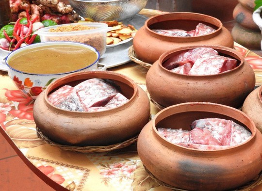 Cá được xếp vào niêu đất cùng với các loại gia vị